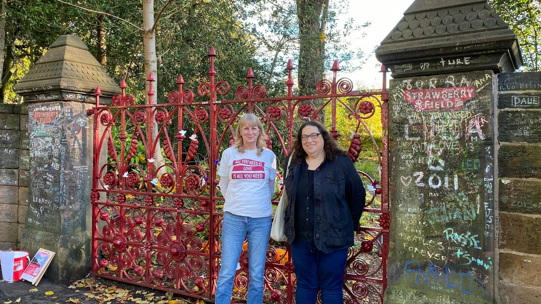 Dozentin Holly Tessler (r.) und ihre Studentin Susan stehen vor dem Eingangstor zu Strawberry Field. 