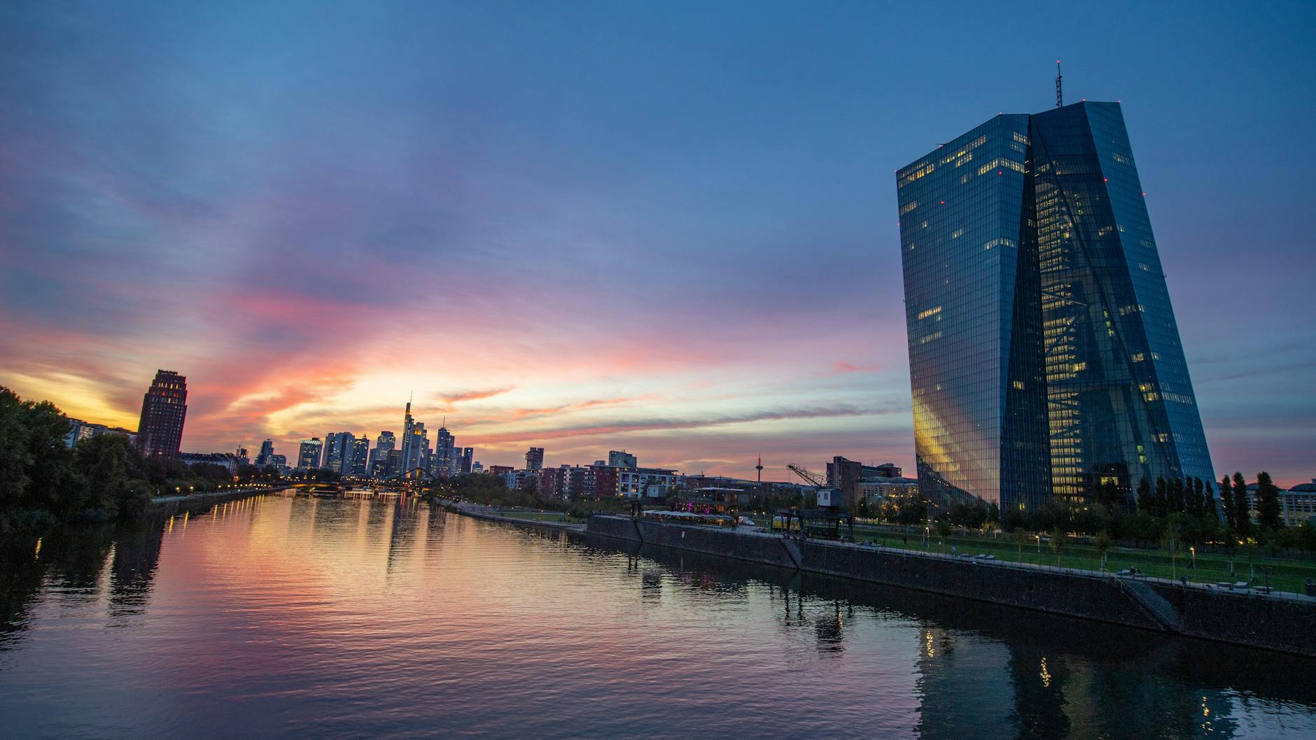 Abenddämmerung in Frankfurt: Die Sonne geht hinter der Bankenskyline unter, während in der Europäischen Zentralbank (EZB) nur noch vereinzelte Lichter zu sehen sind.
