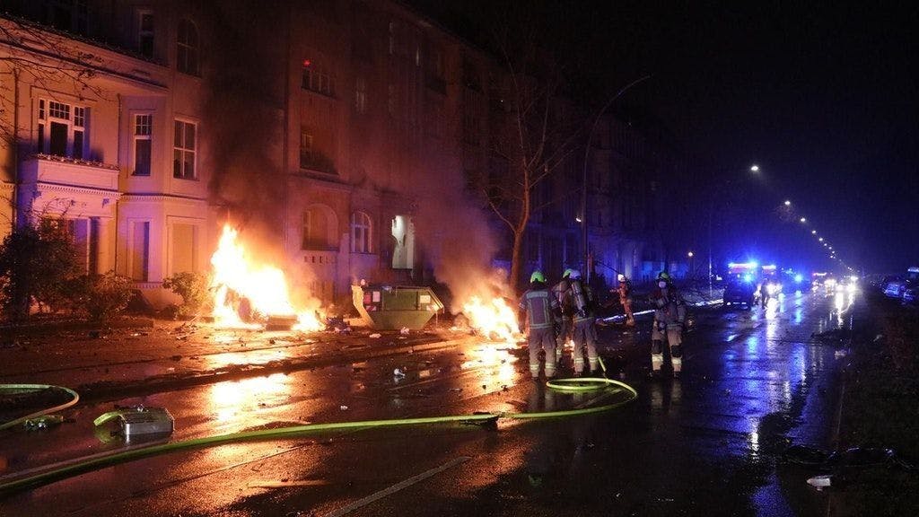 Feuerwehrleute löschen an der Unfallstelle die Trümmer des brennenden Wagens (Archivbild).