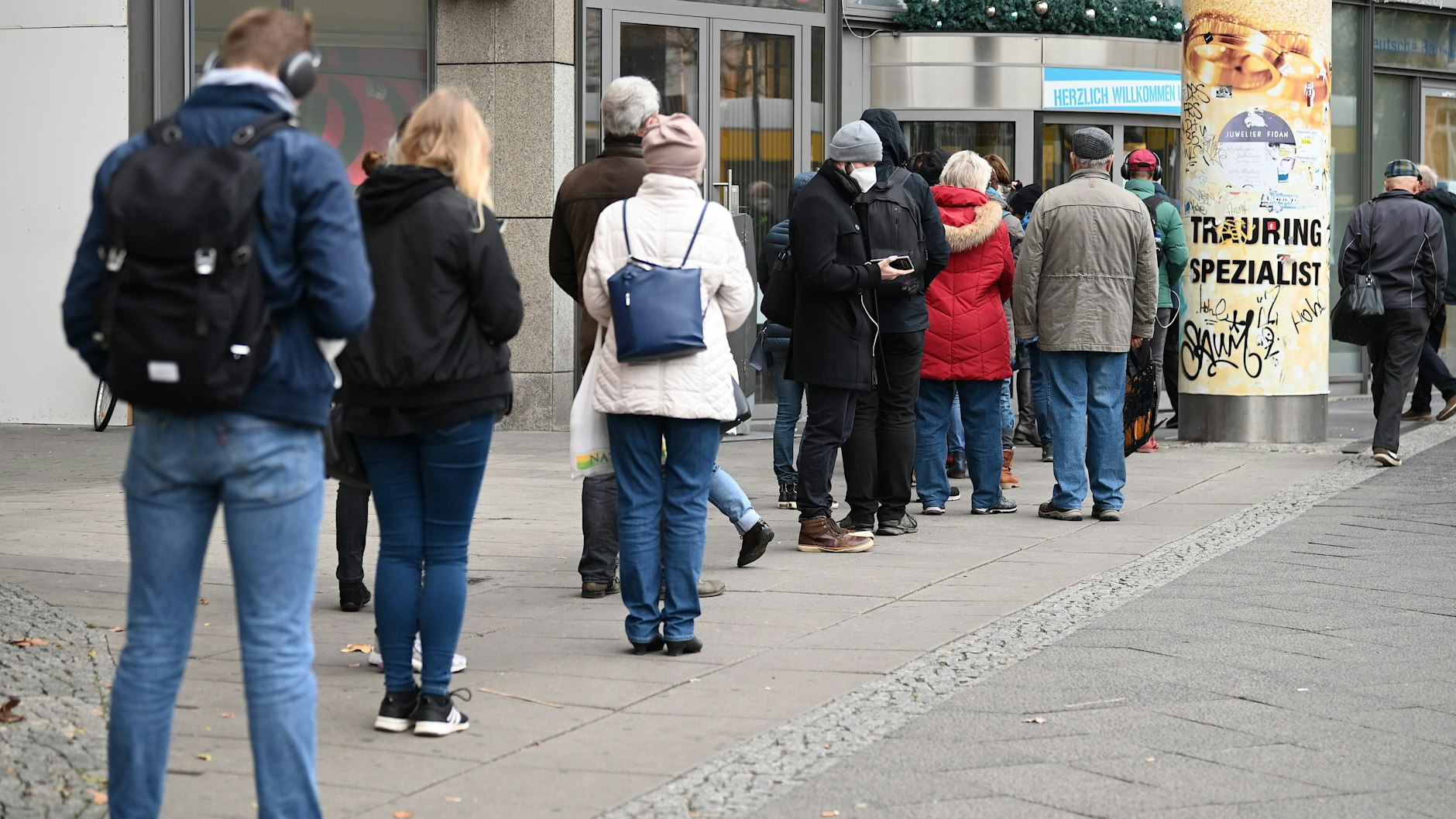Menschen stehen vor der Impfstation Ring-Center an. Das Impfangebot dort wird ab Freitag erweitert.
