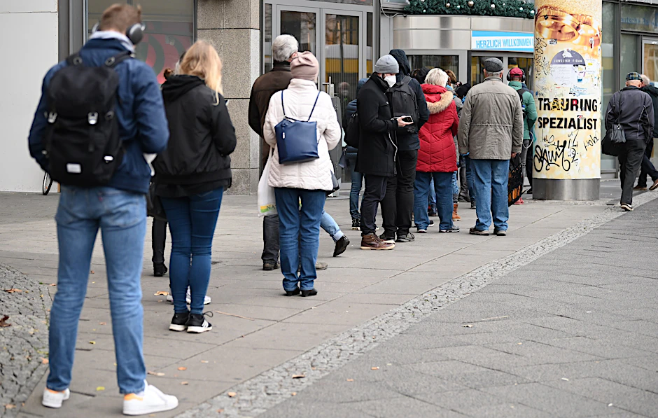 Menschen stehen vor der Impfstation Ring-Center an. Das Impfangebot dort wird ab Freitag erweitert.