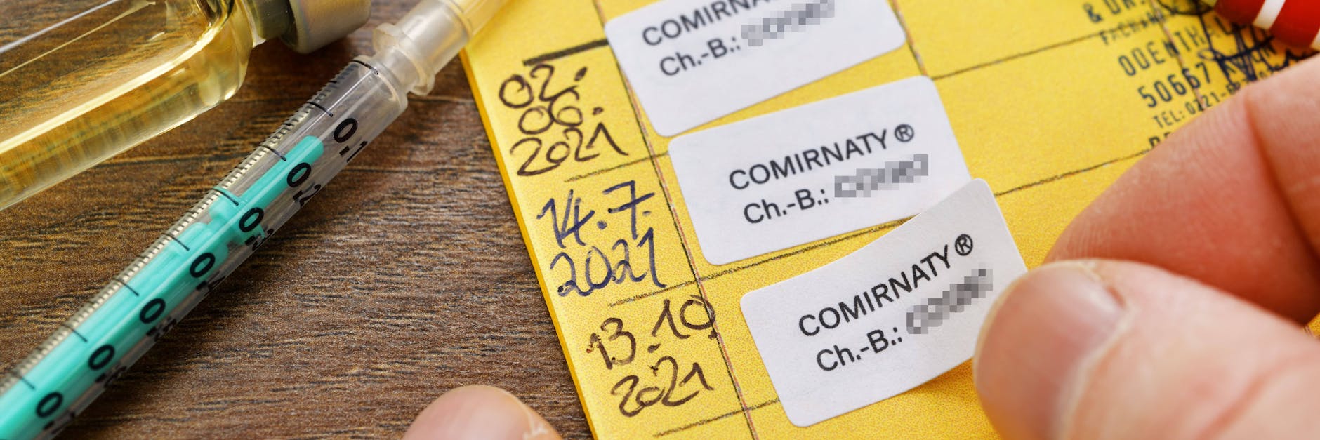 Impfpass mit drei eingetragenen Corona-Impfungen. Das gelbe Heftchen könnte bald nicht mehr als Impfnachweis gelten.