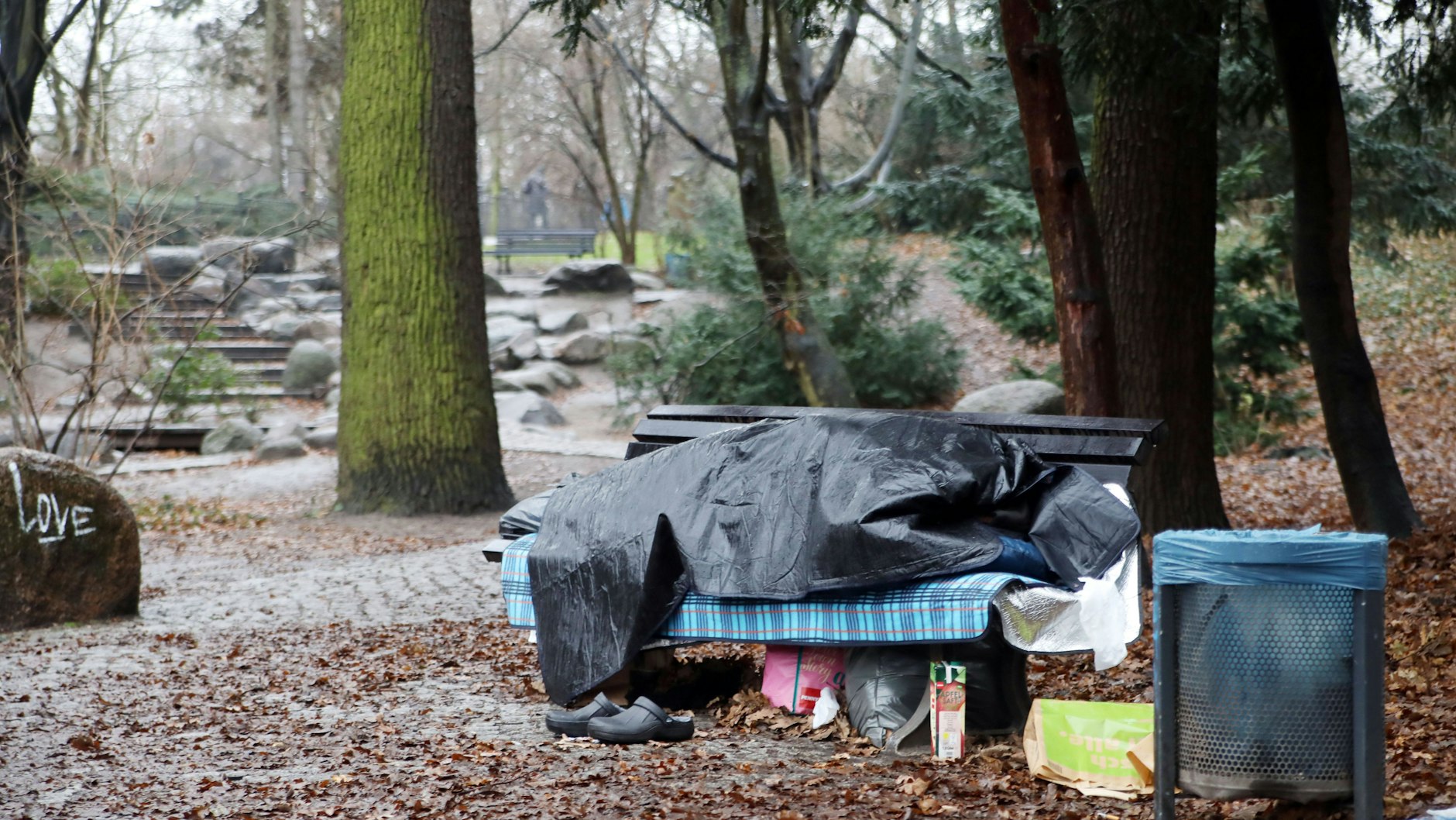 Ein fast schon alltägliches Bild in Berlin: Ein Obdachloser hat in einem Park ein Lager auf einer Bank aufgeschlagen.
