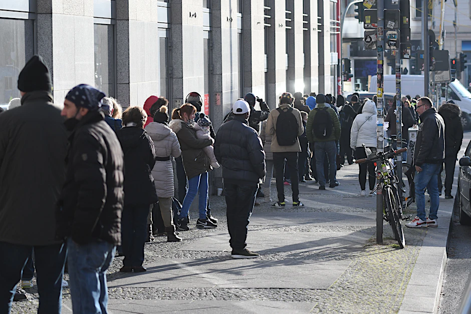 Die Schlange auf der Pettenkoferstraße, bevor sie links um die Ecke die Frankfurter Allee hinunter und zum Eingang des Impfzentrums führt
