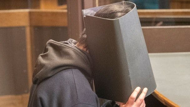 Der Angeklagte Bekim H. verdeckt sein Gesicht.