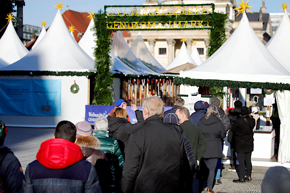 Menschen stehen in einer Schlange am Zugang zum Weihnachtsmarkt am Gendarmenmarkt: Ab Mittwoch gilt hier die 2G Plus-Regel.