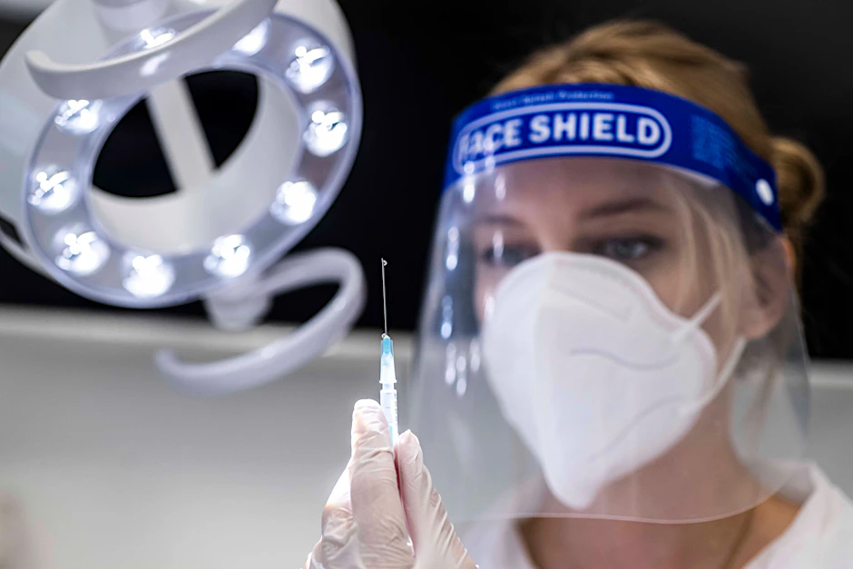 Eine Zahnärztin hält eine Spritze in der Hand (Symbolbild): Die Gesundheitsminister der Länder forcieren Corona-Impfungen in Zahnarztpraxen.&nbsp;