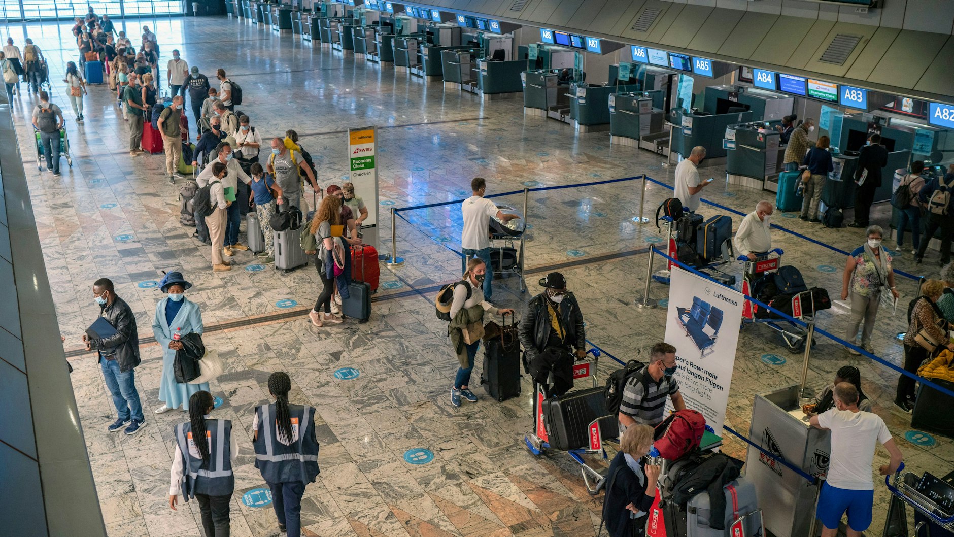 29.11.2021, Südafrika, Johannesburg: Passagiere checken am Lufthansa-Schalter auf dem O.R. Tambo-Flughafen ein. 