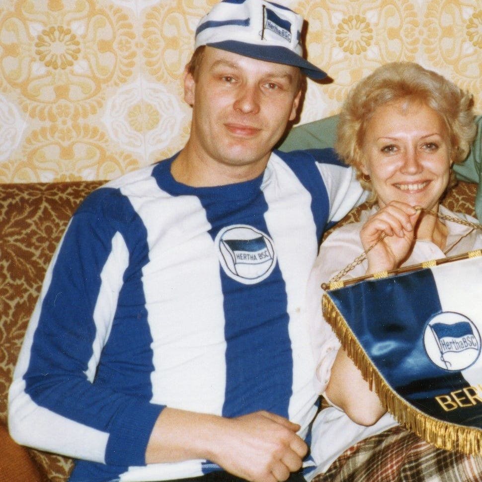 Helmut Klopfleisch mit seiner Frau im Hertha-Trikot und mit Vereins-Wimpel. In ihrer Wohnung waren die Fußballer aus dem Westen zu Gast.
