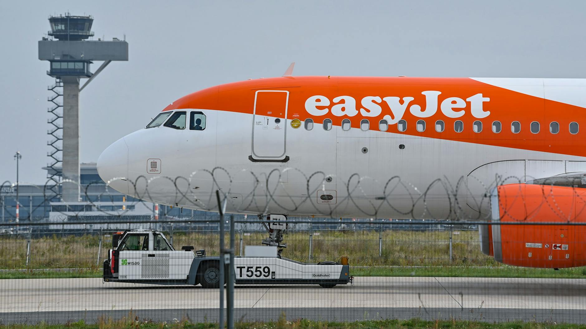 Ein Easyjet-Flugzeug vor der Kulisse des Towers der Deutschen Flugsicherung am BER. Die britische Airline ist die größte Fluggesellschaft am neuen Berliner Hauptstadt-Flughafen.