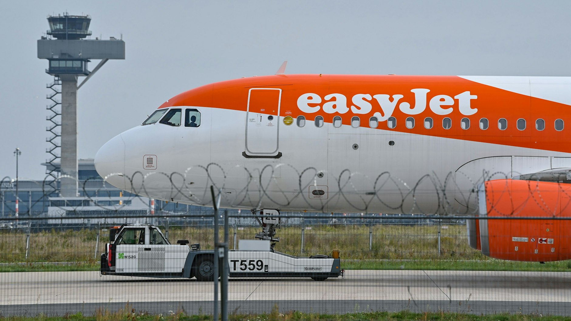Ein Easyjet-Flugzeug vor der Kulisse des Towers der Deutschen Flugsicherung am BER. Die britische Airline ist die größte Fluggesellschaft am neuen Berliner Hauptstadt-Flughafen.