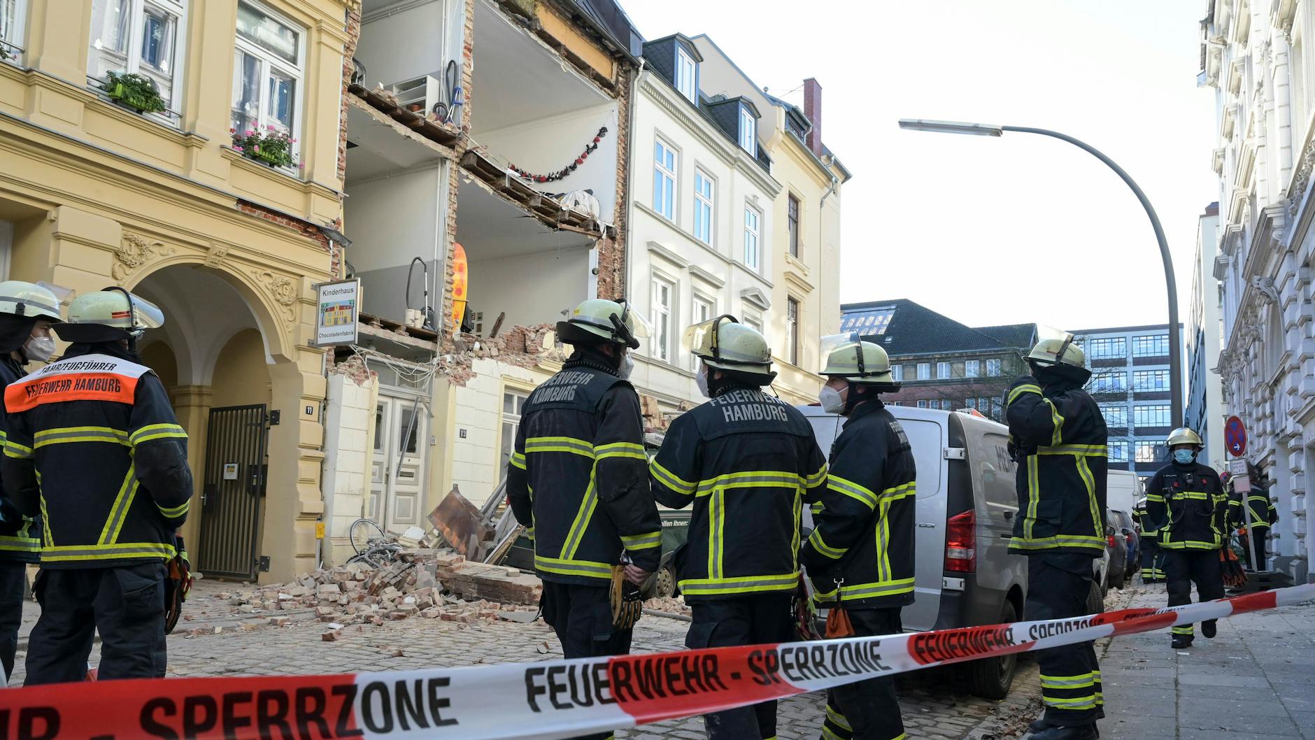 Rettungskräfte der Feuerwehr vor dem zerstörtes Haus.
