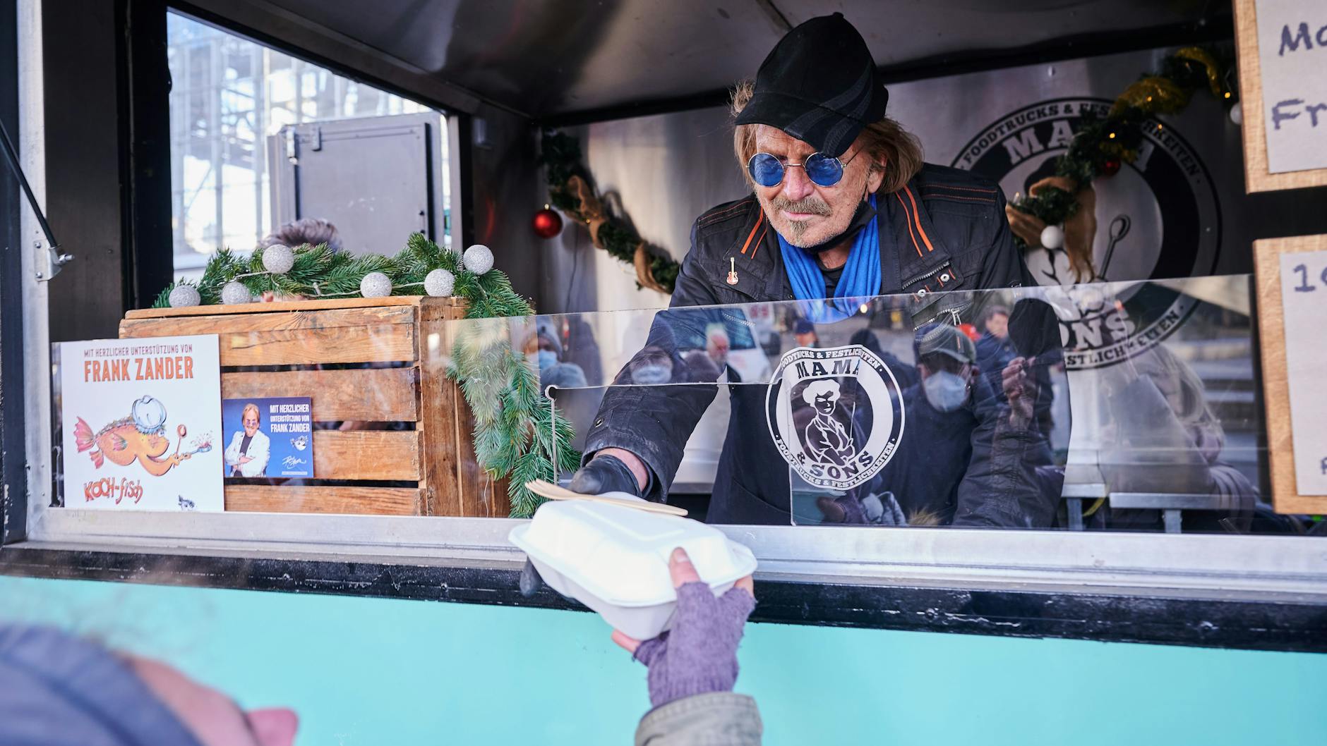 Frank Zander steht im Caritas-Foodtruck und verteilt warme Mahlzeiten an Obdachlose und bedürftige Menschen auf dem Alexanderplatz. 