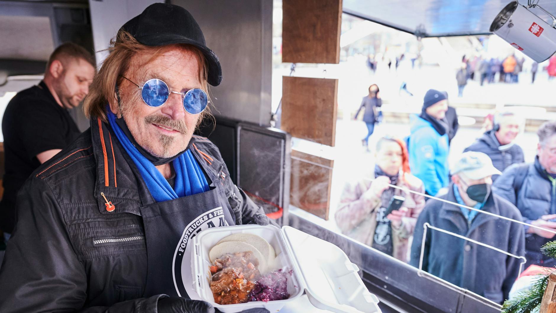 Frank Zander steht im Caritas-Foodtruck und verteilt warme Mahlzeiten an Obdachlose und bedürftige Menschen auf dem Alexanderplatz.