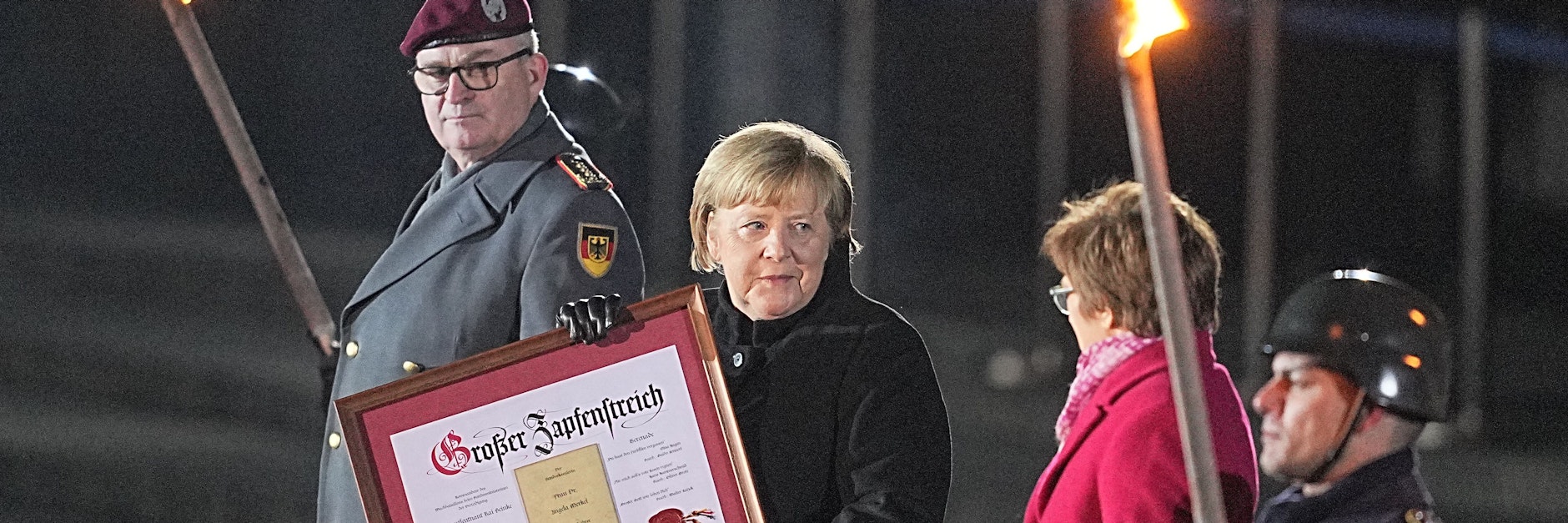 Bundeskanzlerin Angela Merkel (CDU) steht bei ihrer Verabschiedung durch die Bundeswehr zwischen dem Generalinspekteur der Bundeswehr, General Eberhard Zorn (l), und der Verteidigungsministerin Annegret Kramp-Karrenbauer (CDU). Mit einem Großen Zapfenstreich wurde Kanzlerin Merkel gegen Ende ihrer Regierungszeit nach 16 Jahren im Bendlerblock verabschiedet.&nbsp;