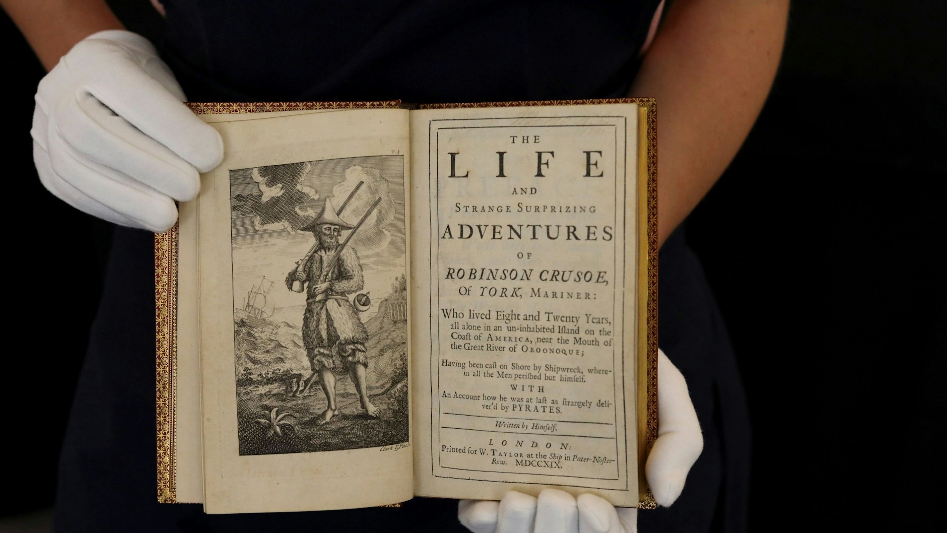 Eine Mitarbeiterin von Sotheby's zeigt eine Erstausgabe von 1719 des Romans: „The Life and Strange Surprizing Adventures of Robinson Crusoe of York, Mariner“ des britischen Schriftstellers Daniel Defoe.