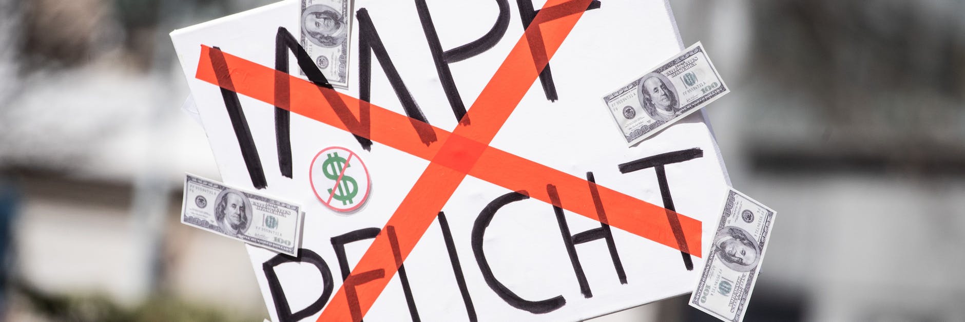 Ein Mann trägt auf einer Demonstration der Initiative „Querdenken“ ein Schild mit dem durchgestrichenen Wort „Impflicht“.