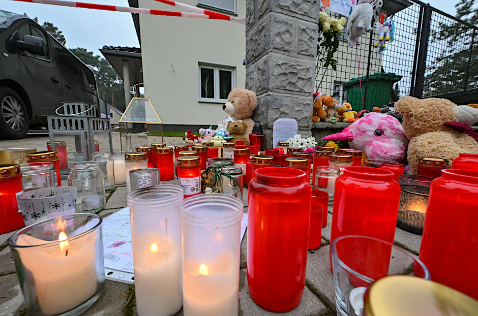 Viele Kerzen brennen auf einem Gehweg vor einem Einfamilienhaus in Königs Wusterhausen. Am Wochenende sind in dem Haus fünf Menschen erschossen worden.