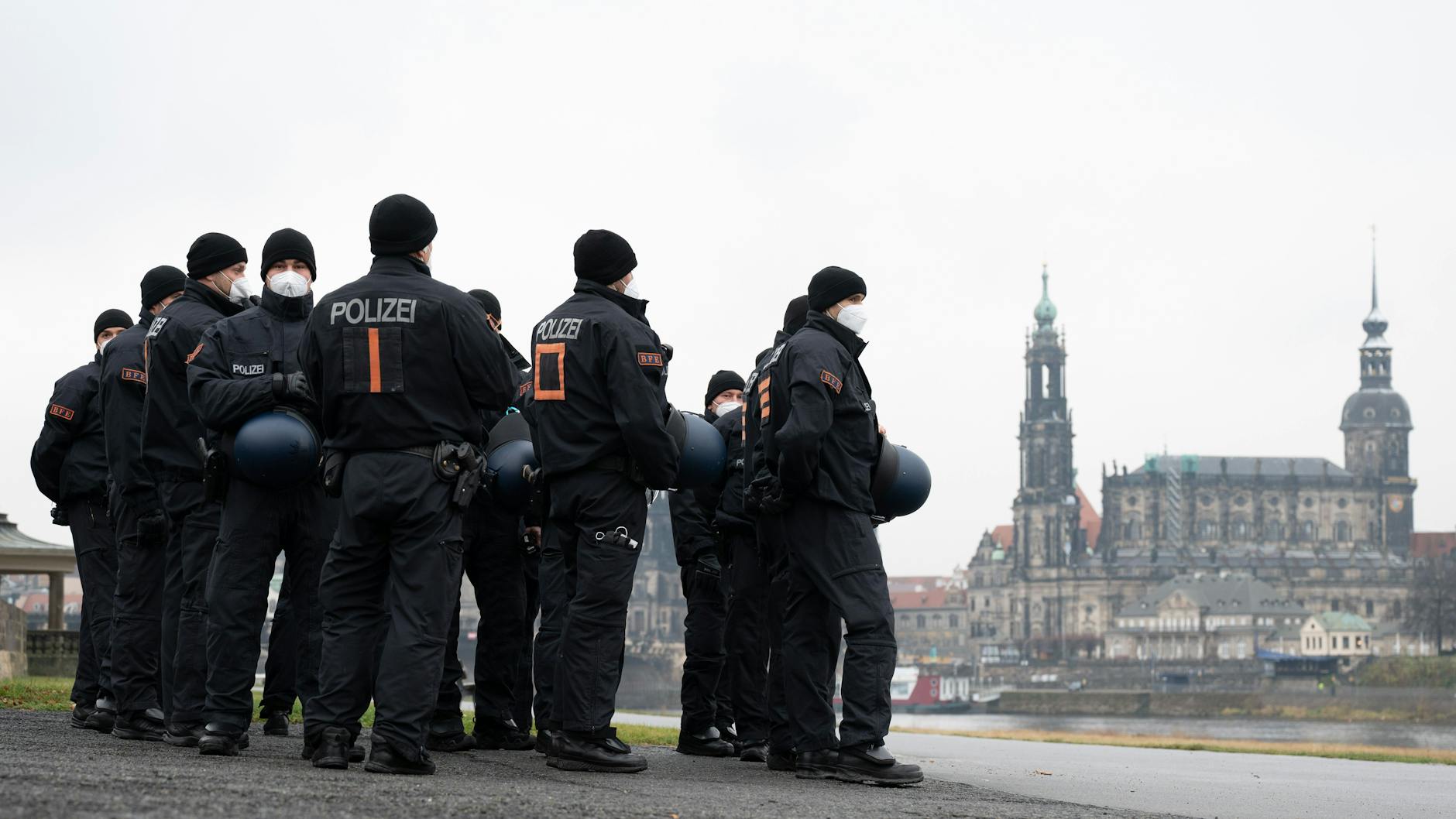 Polizisten stehen am Ufer der Elbe. Anlässlich der Landtagssitzung zur Feststellung der epidemischen Lage im Freistaat rechnete die Polizei mit einem Protest von Gegnern der Corona-Politik. 