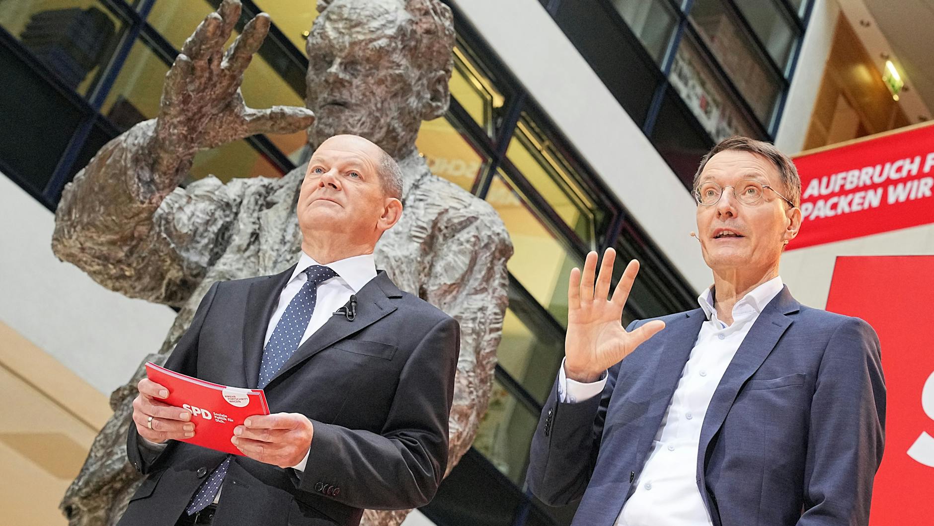 Der designierte Bundeskanzler Olaf Scholz (SPD) stellt Karl Lauterbach als künftigen Bundesminister für Gesundheit vor. Sie stehen unter der großen Willy-Brandt-Skulptur in der SPD-Bundeszentrale in Berlin.
