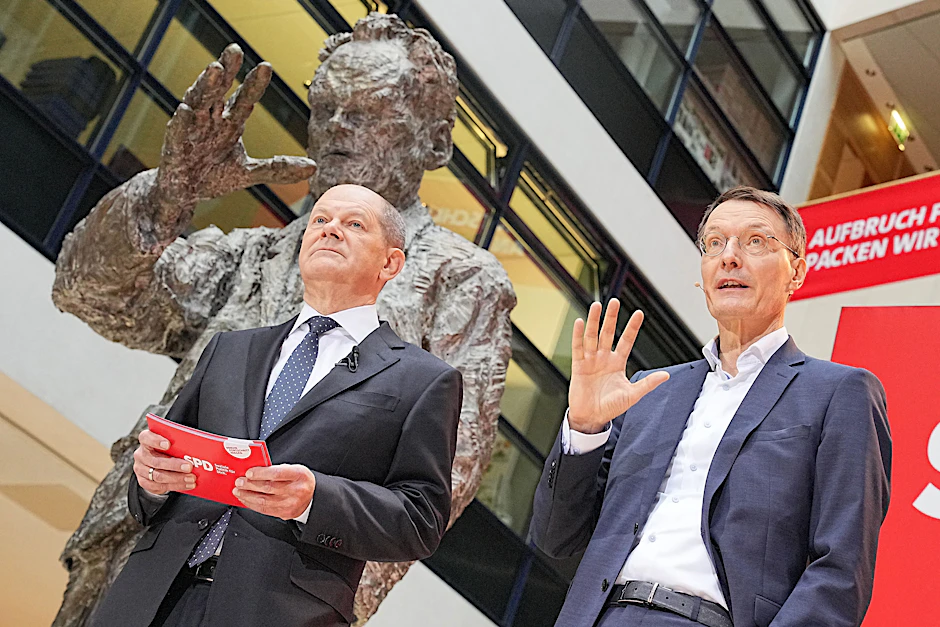 Der designierte Bundeskanzler Olaf Scholz (SPD) stellt Karl Lauterbach als künftigen Bundesminister für Gesundheit vor. Sie stehen unter der großen Willy-Brandt-Skulptur in der SPD-Bundeszentrale in Berlin.