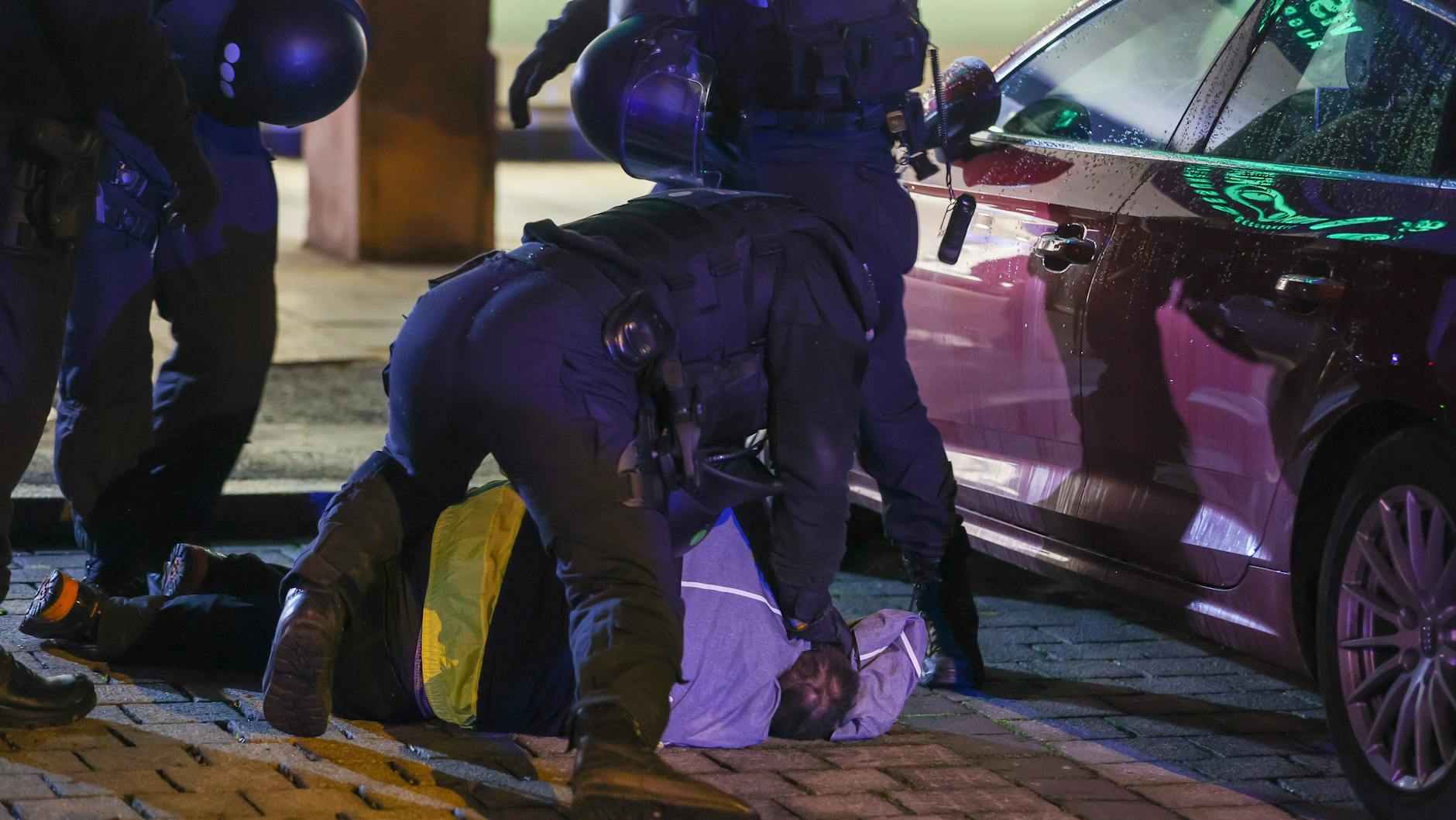 Einsatzkräfte der Polizei fixieren einen Teilnehmer einer nicht genehmigten Demonstration gegen die Corona-Maßnahmen in Chemnitz auf dem Boden.
