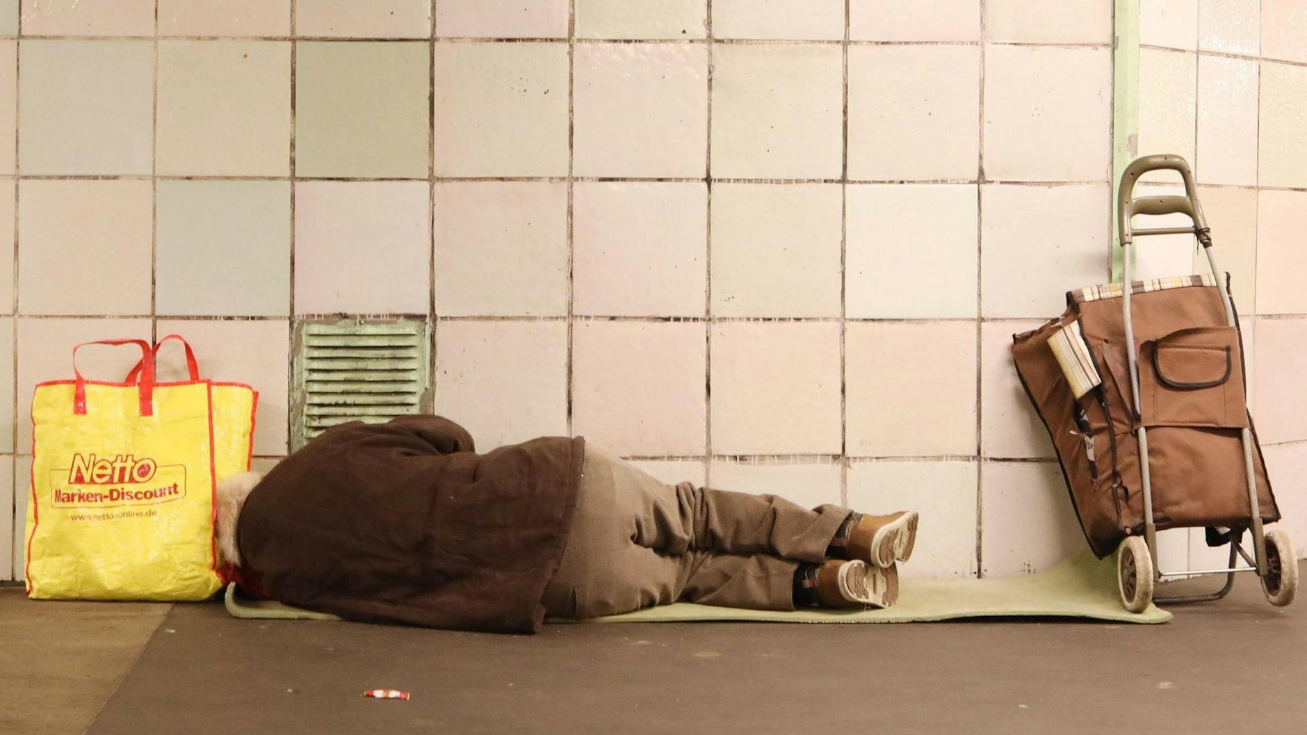 Ein obdachloser Mann liegt in einem Bahnhof in Berlin-Kreuzberg.