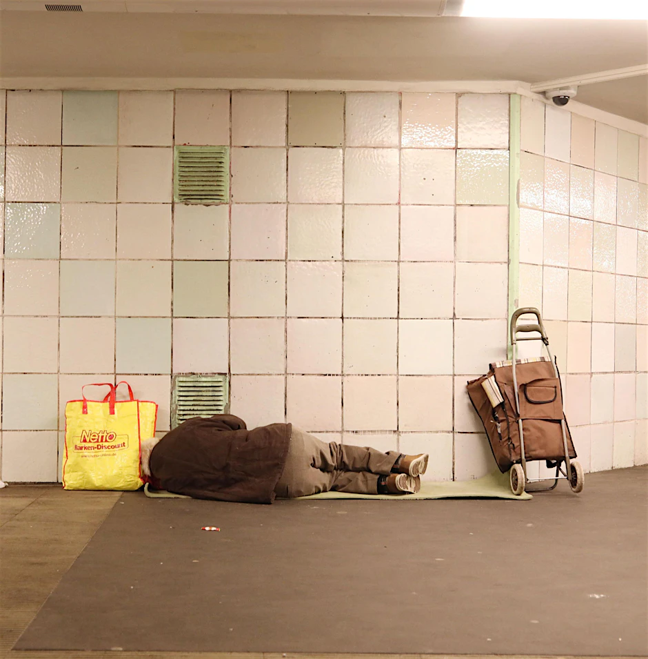Ein obdachloser Mann liegt in einem Bahnhof in Berlin-Kreuzberg.