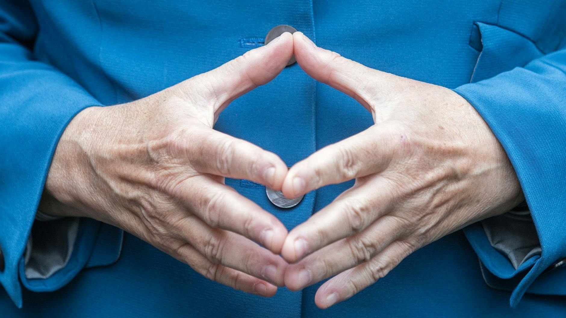 Bundeskanzlerin Angela Merkel (CDU) hat beim Bürgerfest im Garten von Schloss Bellevue in Berlin ihre Hände zu einer Raute geformt.