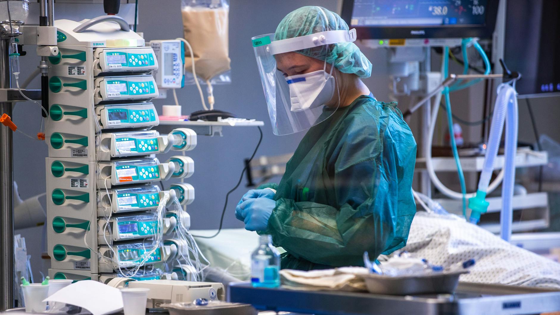 Eine Intensivschwester betreut einen Patienten in einem der Behandlungszimmer der Intensivstation. 