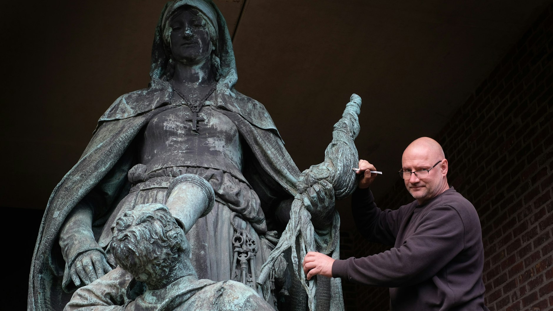 Bernd M. Helmich entfernte in seiner Werkstatt in Altglienicke Kalkablagerungen von der Gertrauden-Skulptur.