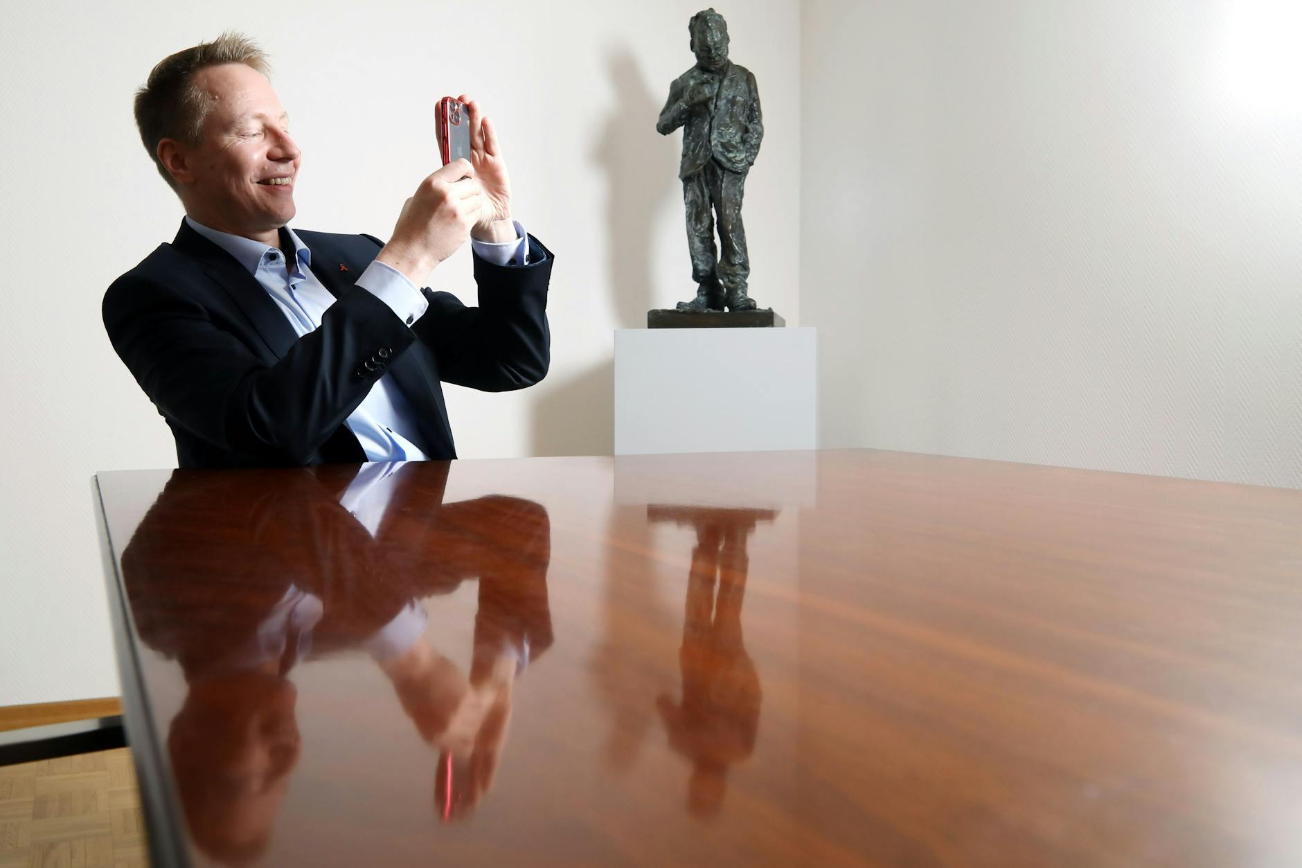 Dennis Buchner, Präsident des Abgeordnetenhauses, fotografiert in seinem Büro mit seinem Handy.