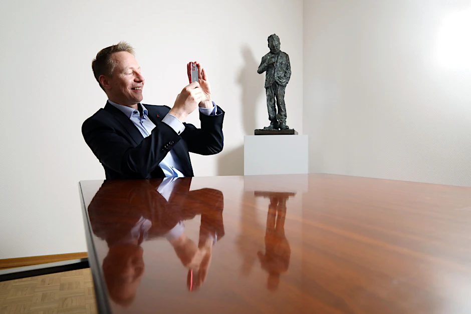 Dennis Buchner, Präsident des Abgeordnetenhauses, fotografiert in seinem Büro mit seinem Handy.