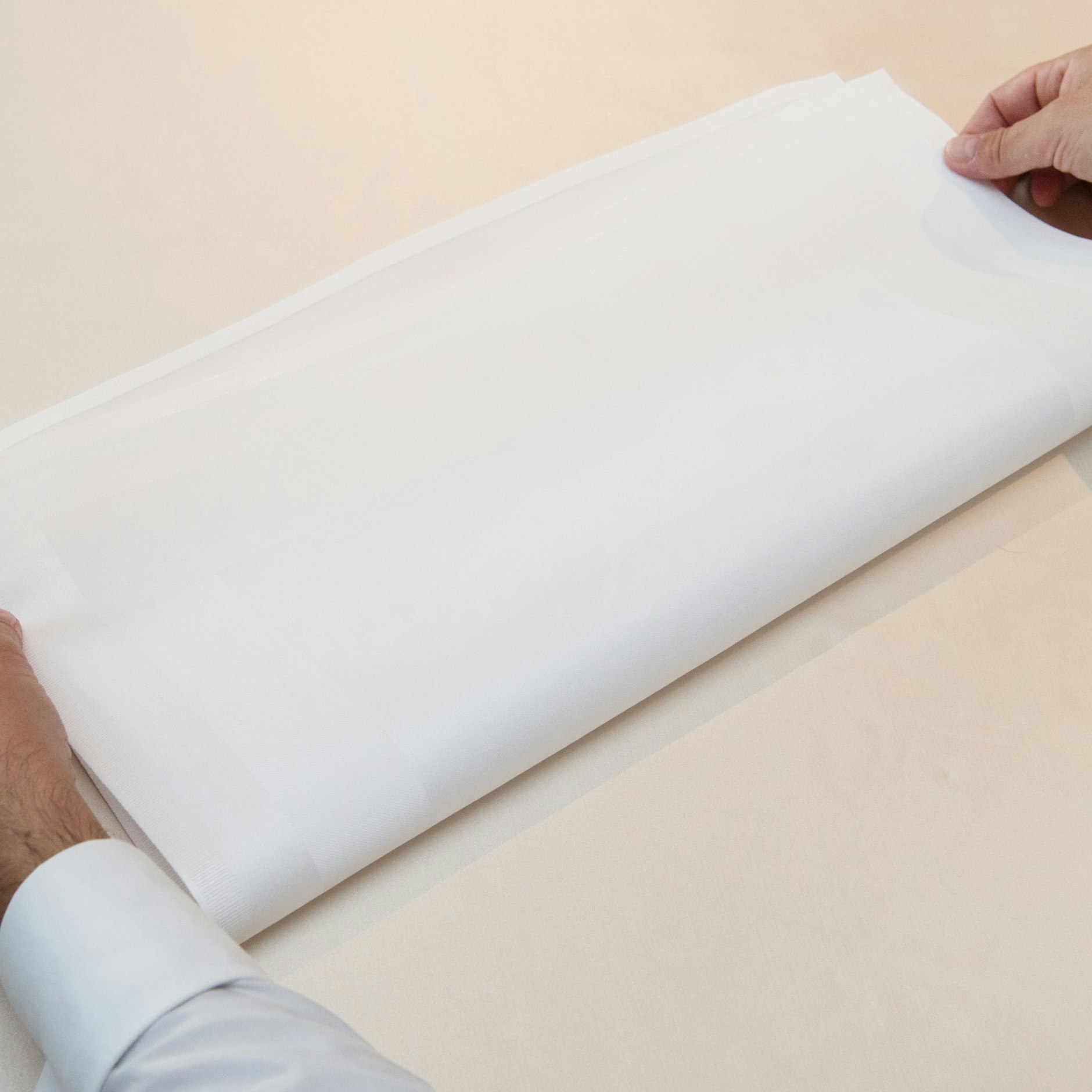 Schritt 1: Die Serviette als Quadrat auf den Tisch legen und anschließend zum Rechteck halbieren.