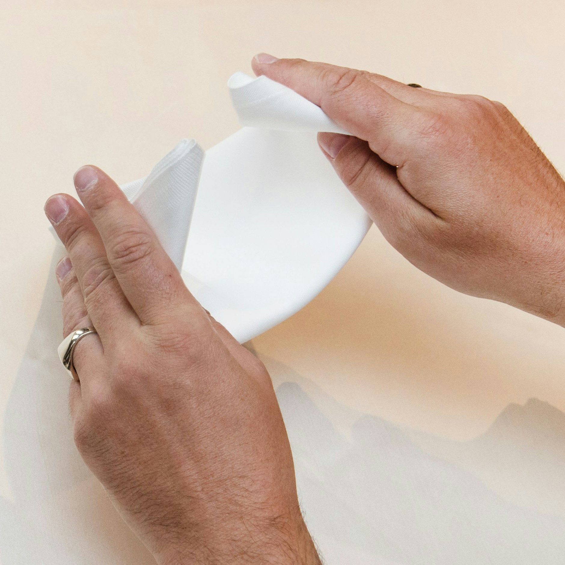 Schritt 4: Auf der Rückseite die beiden Ecken der langen Dreiecksseite ineinanderstecken.