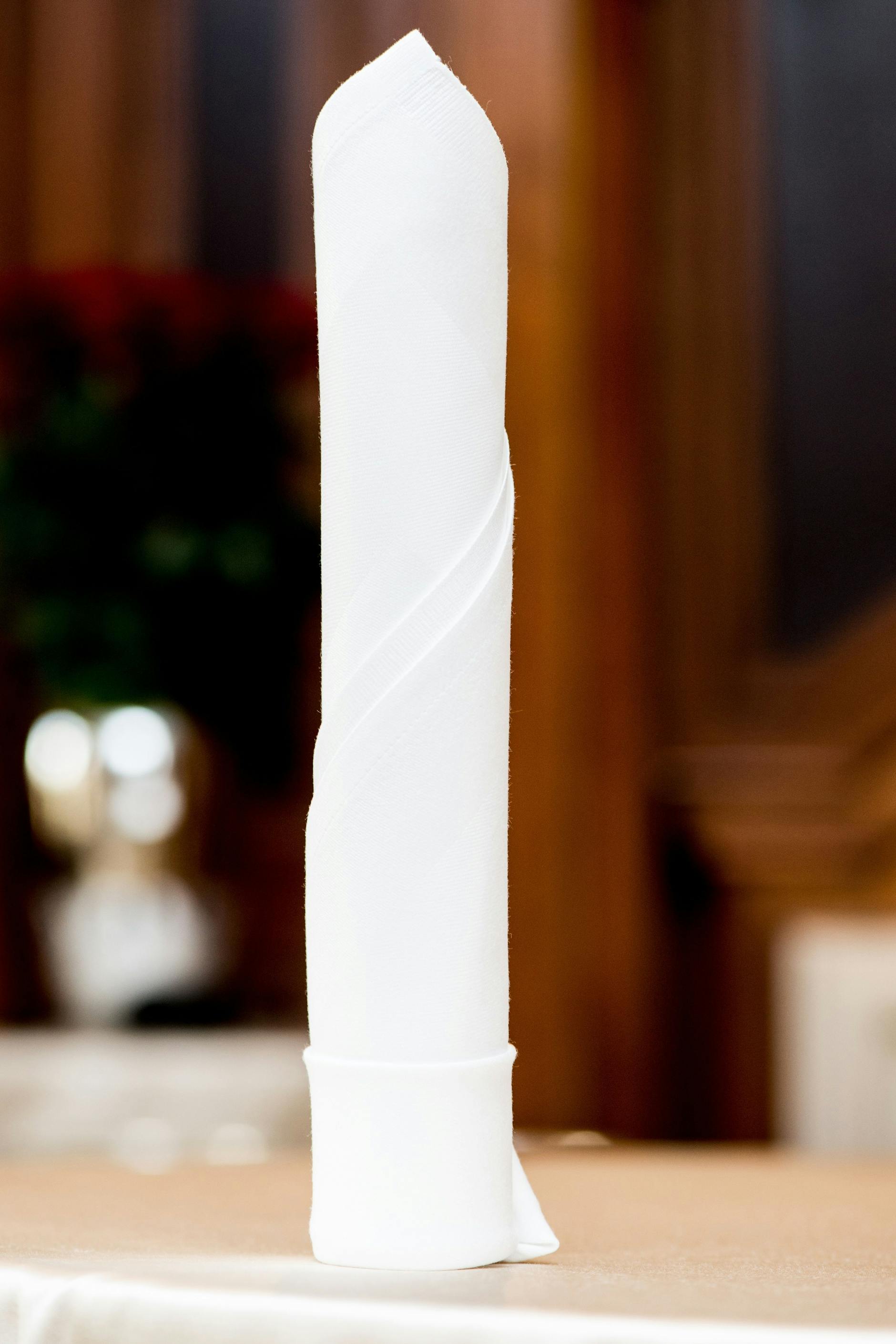 Die in Kerzenform gefaltete Serviette eignet sich besonders für flach eingedeckte Tische.