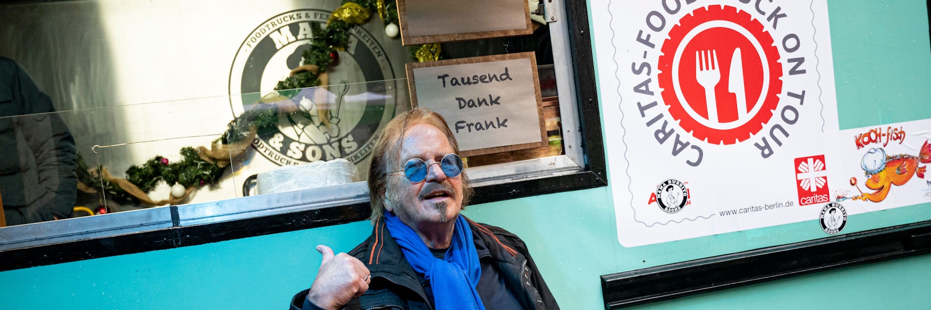 Frank Zander, Musiker, steht bei seiner Weihnachtsaktion vor einem Food-Truck der Caritas. 