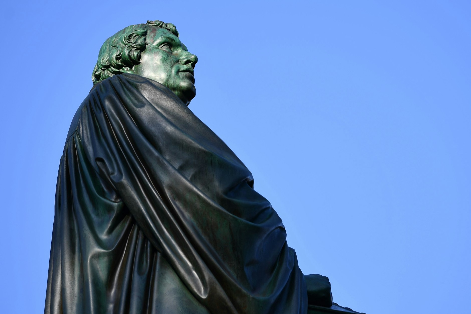 Eine Figur des Reformators Martin Luther aus Bronze steht als Teil des Luther-Denkmals in Worms.