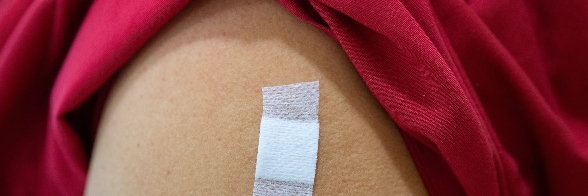 Eine Mitarbeiterin im Alten- und Pflegeheim Bürgerheim hat nach der Corona-Impfung mit dem Impfstoff von Biontech/Pfizer ein Pflaster auf dem Oberarm kleben.