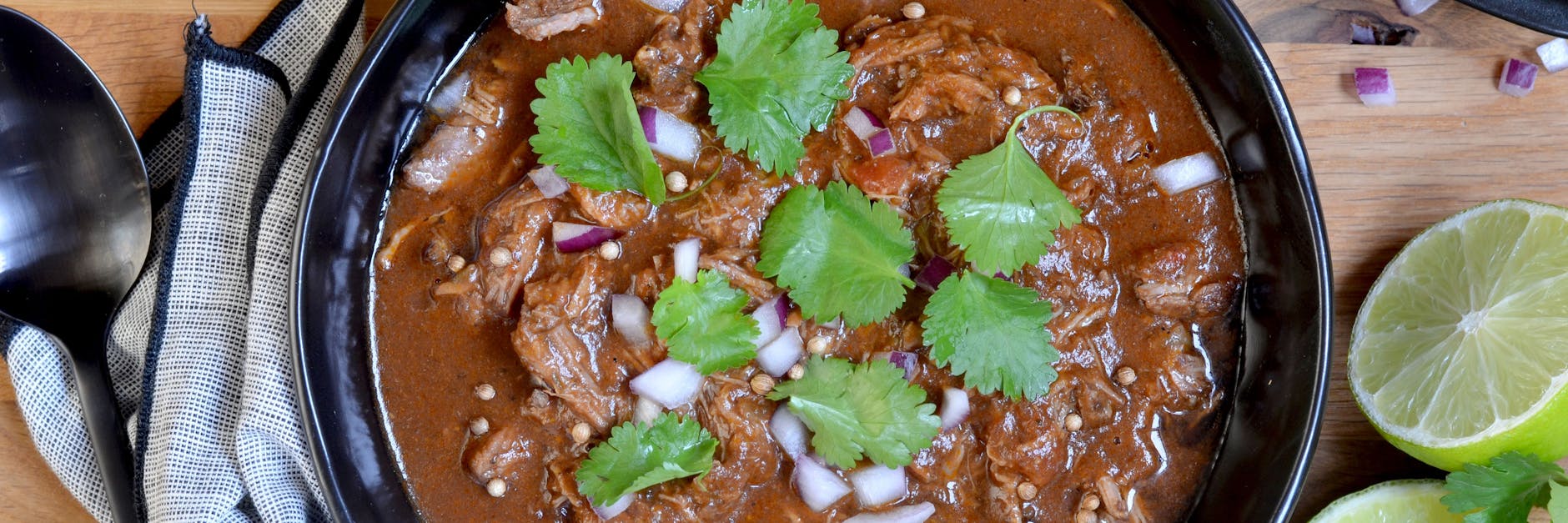 Der Mexikanische Rindereintopf kann gelöffelt, aber auch in eine Tortilla zusammen mit Zwiebeln, Koriander und Chili gewickelt werden. 