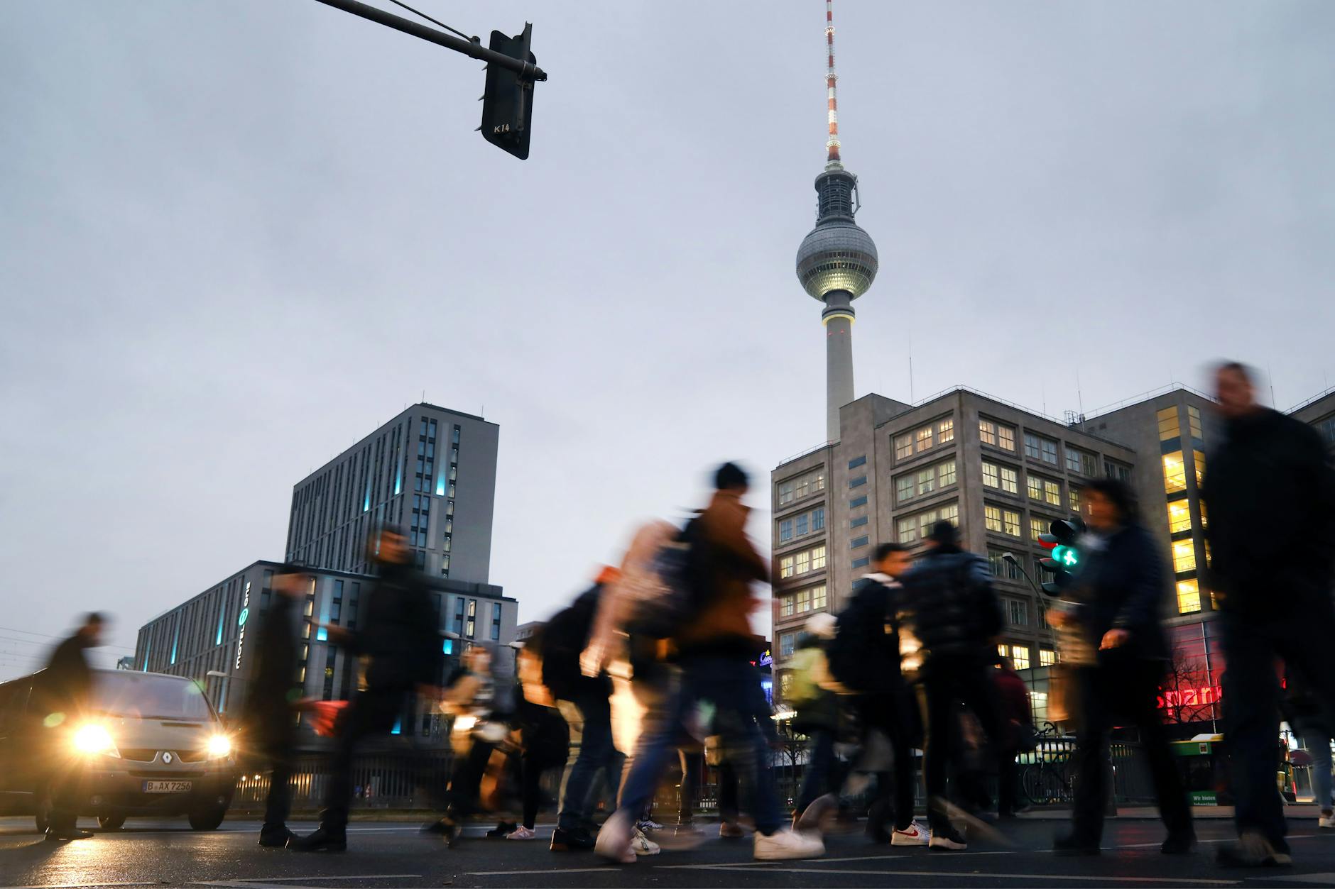 Berlin: Menschen eilen über einen Fußgängerüberweg am Alexanderplatz in Mitte.