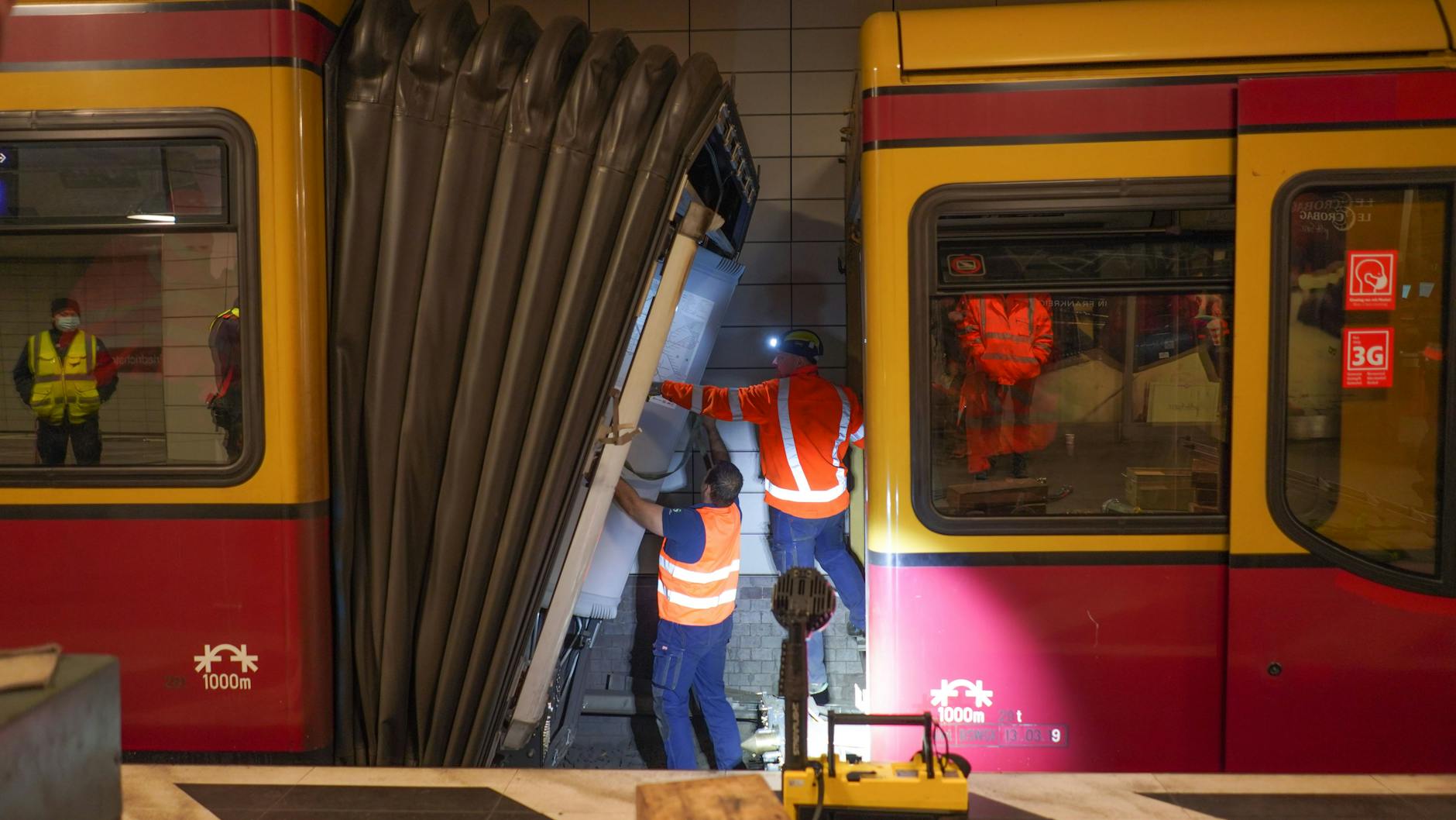 S-Bahner sind dabei, den teilweise entgleisten Zugverband zu trennen. 