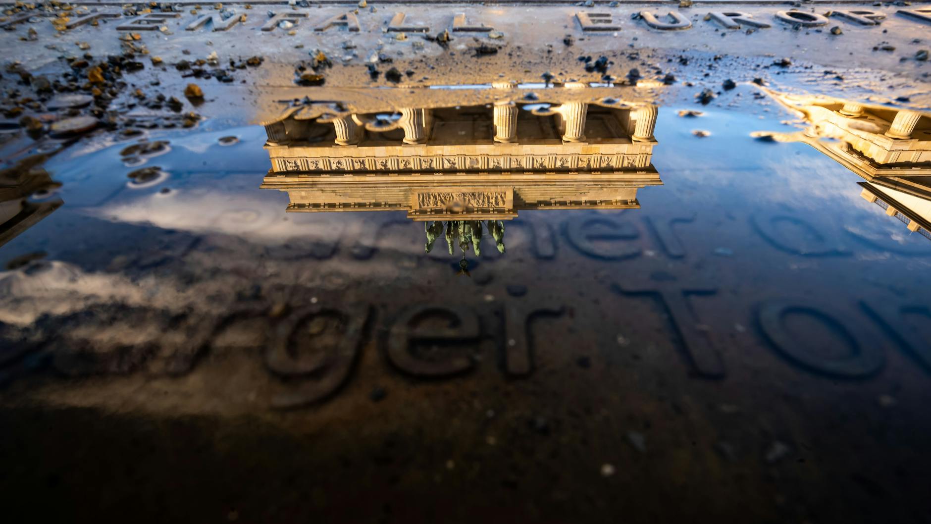 Das Brandenburger Tor spiegelt sich in einer kleinen Pfütze auf dem Pariser Platz.