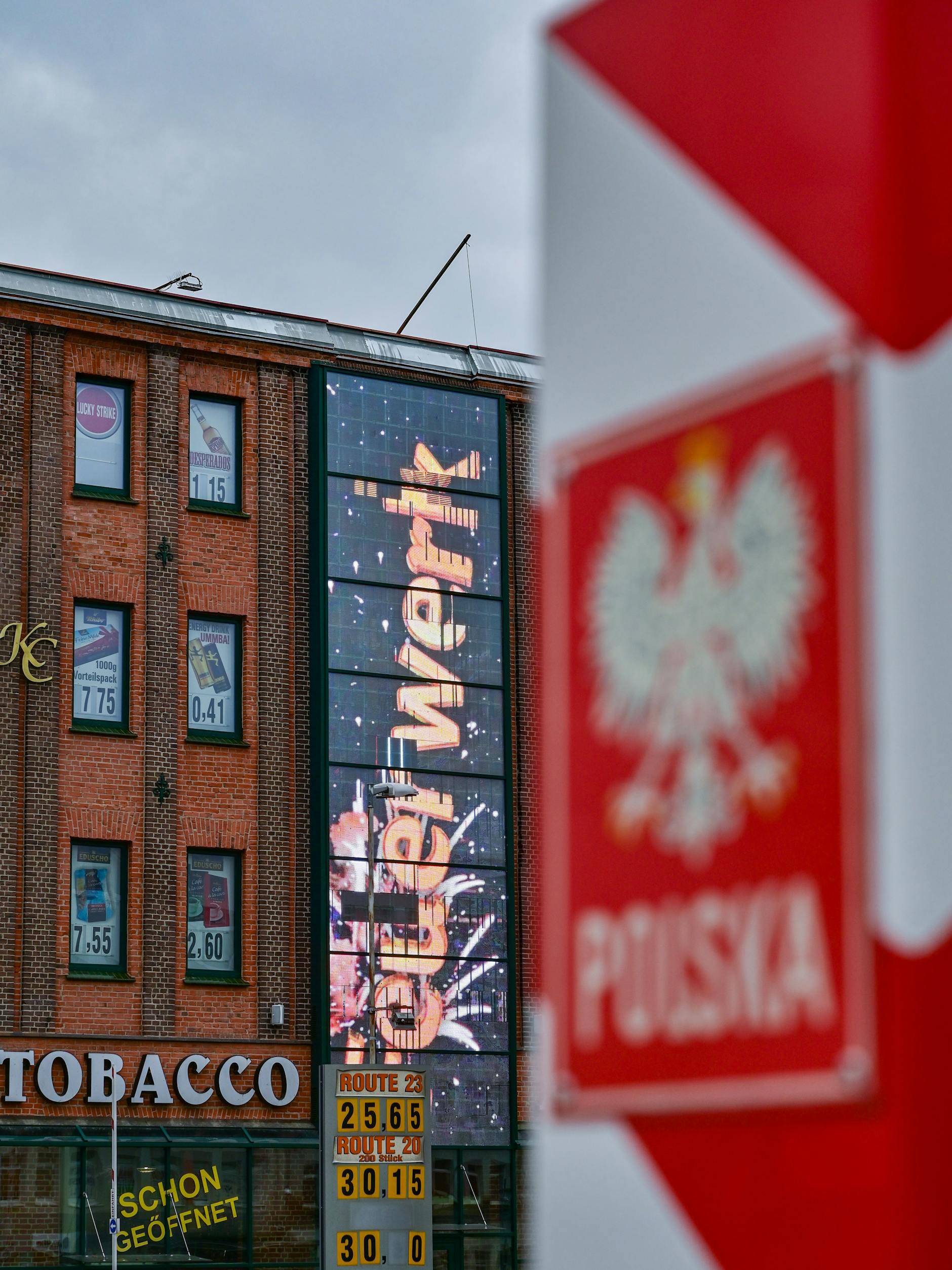Im polnischen Grenzort Slubice ist gleich hinter einem Grenzpfeiler ist eine große Leuchtreklame für Silvesterfeuerwerk zu sehen.