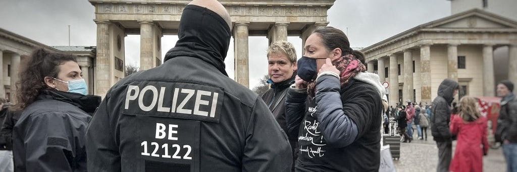 Polizisten erklären den Menschen am Brandenburger Tor, dass keine Demo stattfinden wird.