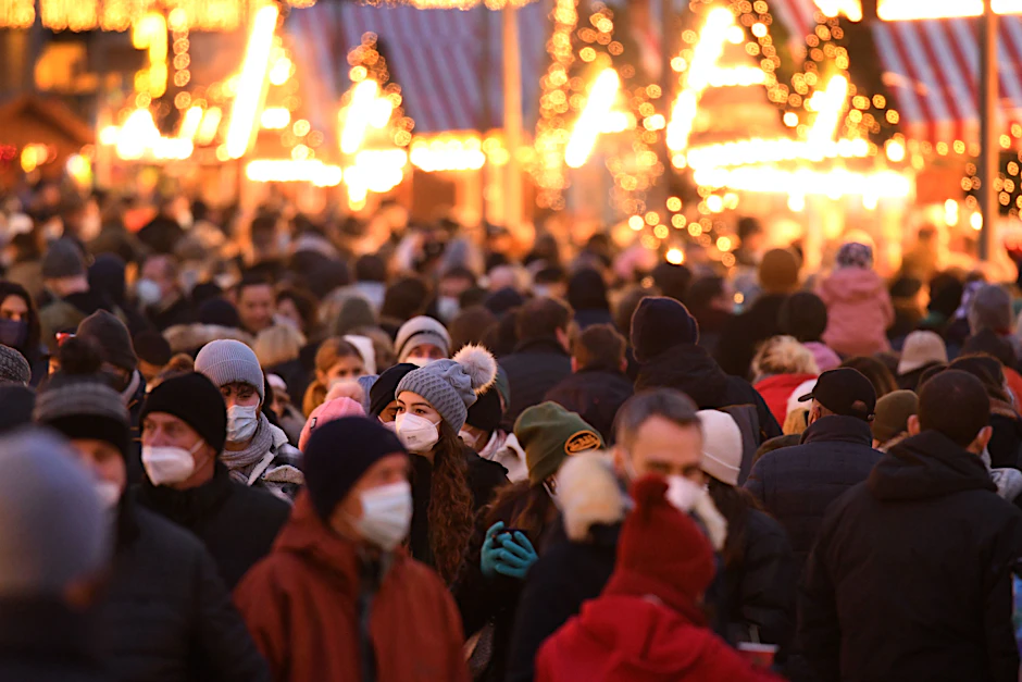 Menschen mit Masken auf einem Berliner Weihnachtsmarkt