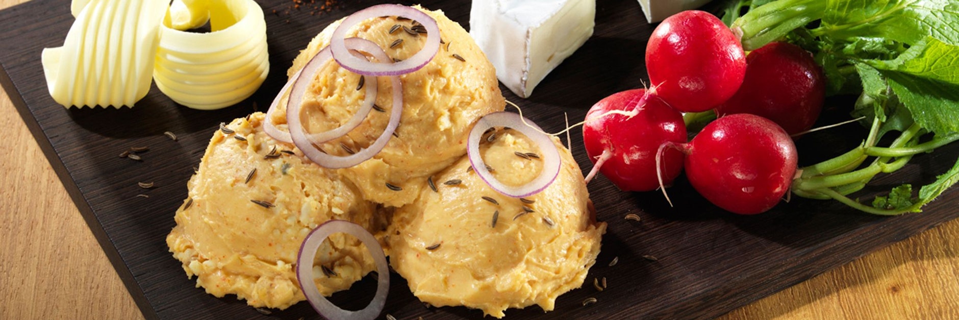 Die frischen Zwiebelringe kommen am besten erst kurz vor dem Servieren auf den Obazda.