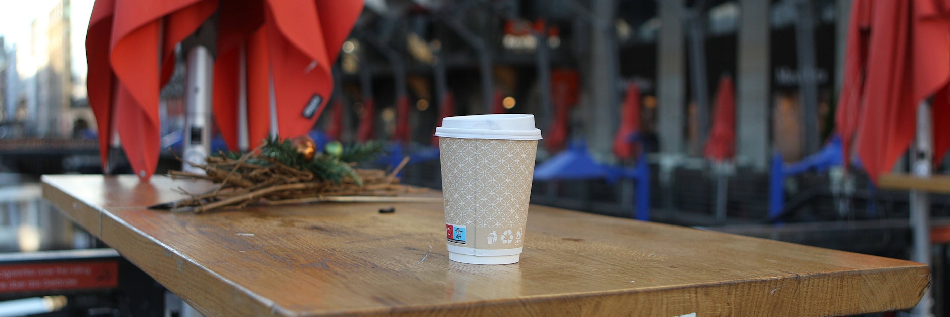 Ein Becher steht auf dem Tisch eines menschenleeren Cafes in der Hamburger Innenstadt.