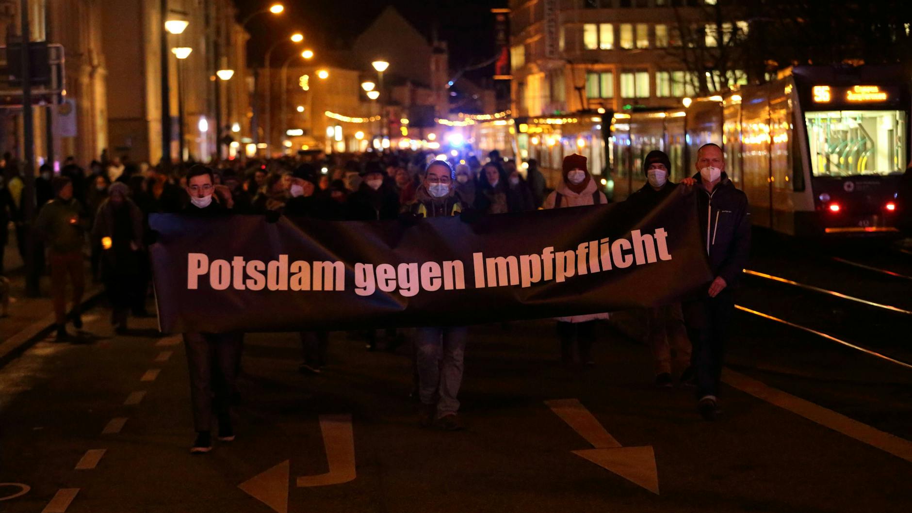 Demonstranten gehen am Montagabend mit einem Banner über die Friedrich-Ebert-Straße.