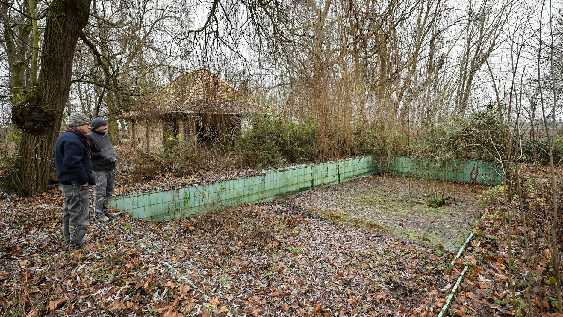Detlef Mallwitz (l), Künstler und Jörg Engelhardt, stehen vor einem ehemaligen Schwimmbecken im verwilderten Park des einstigen Rittergutes Jäckelsbruch, wo früher der Bildhauer Arno Breker arbeitete. 